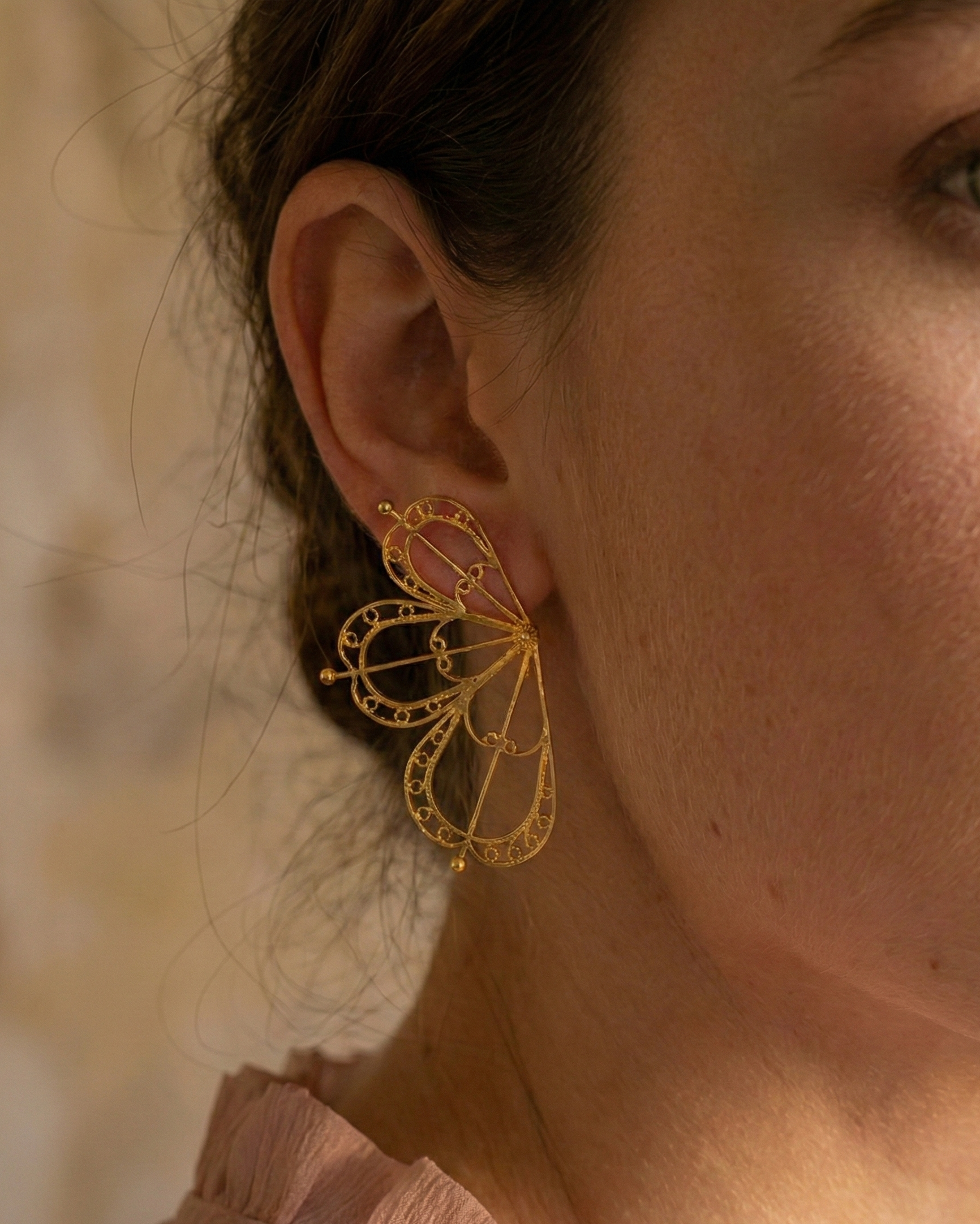 Modelo usando los pendientes abanico expansivos de DAILA que enmarcan el rostro con elegancia y ligereza.