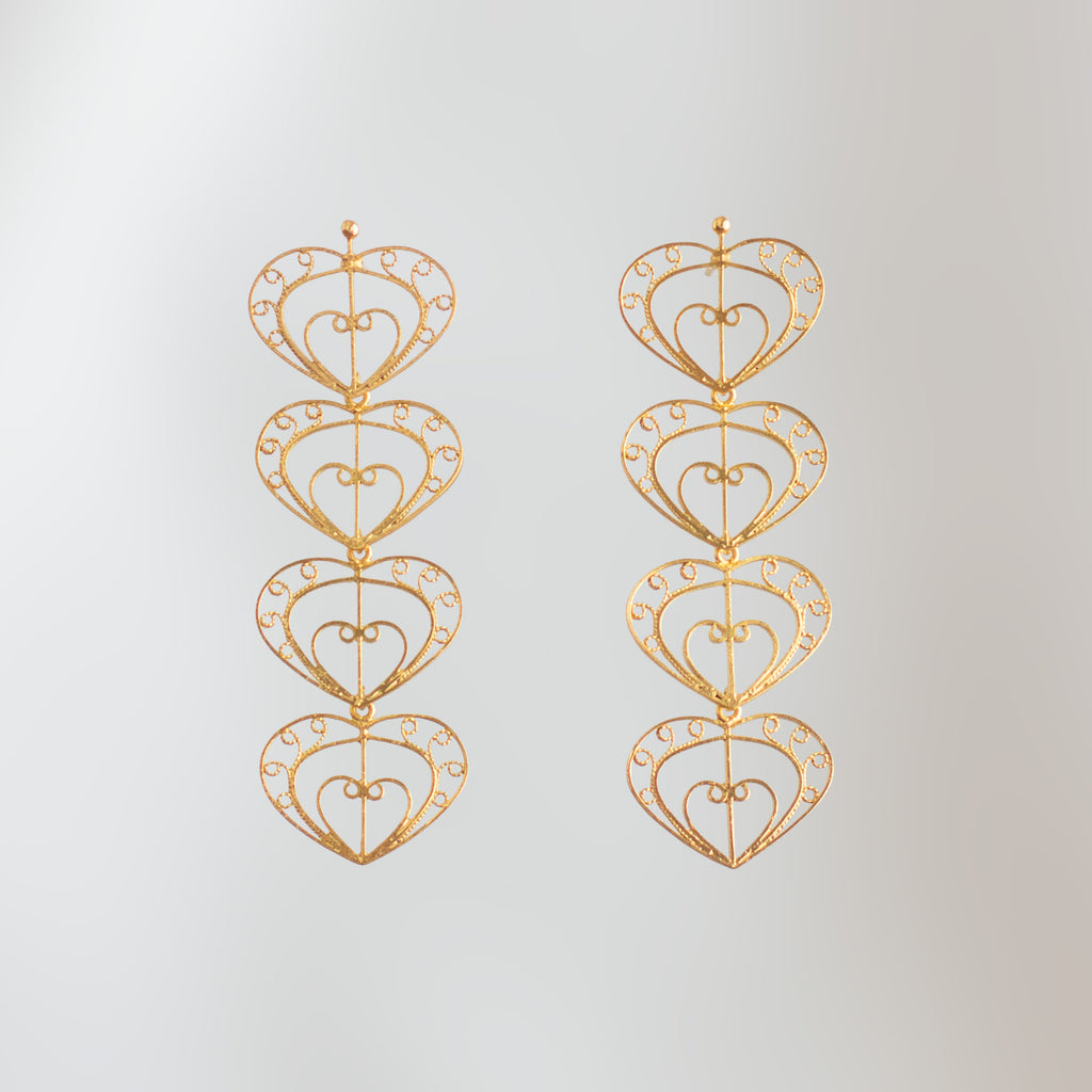 Pendientes largos Cuatro Latidos de filigrana momposina dorada con cuatro corazones tejidos.