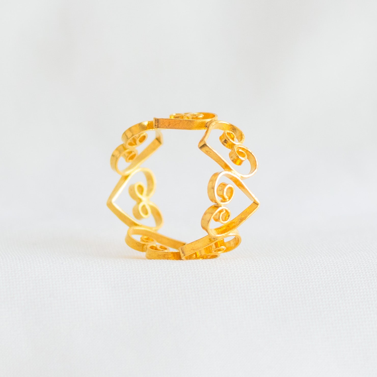 Anillo de corazones en filigrana de Mompox dorada con diseño calado y romántico.