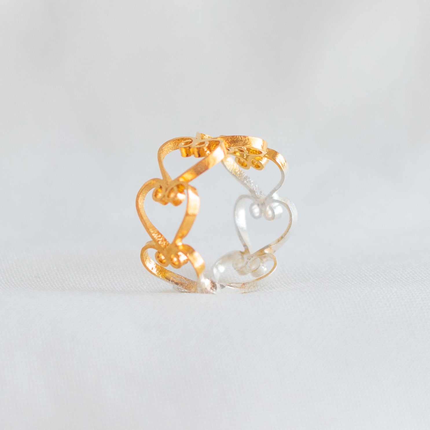 Detalle del tejido artesanal en anillo de plata 950 con corazones DAILA.